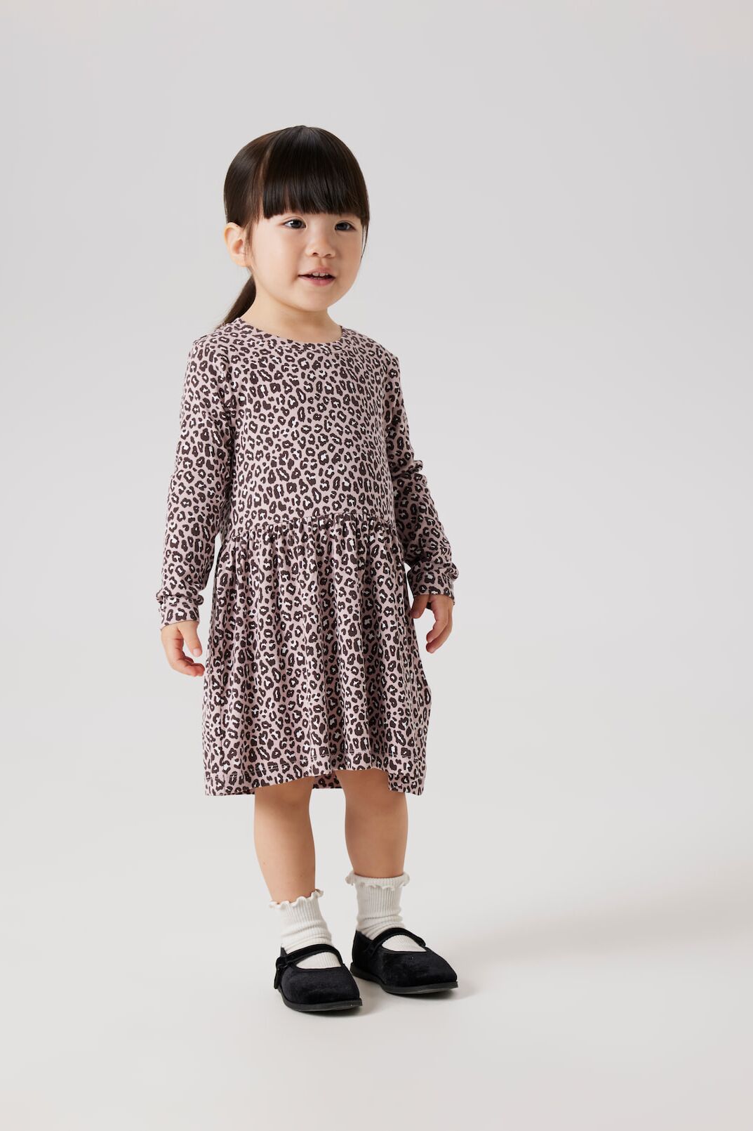 Kleines Mädchen in süßen Kleid mit Musterprint von name it schaut fasziniert