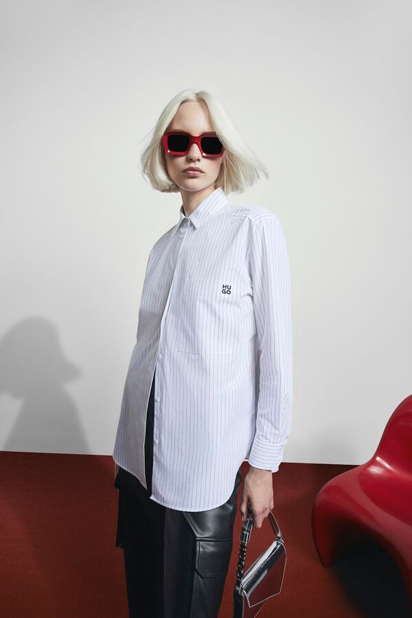 Weibliches Model in blauer Bluse und roter Sonnenbrille von BOSS