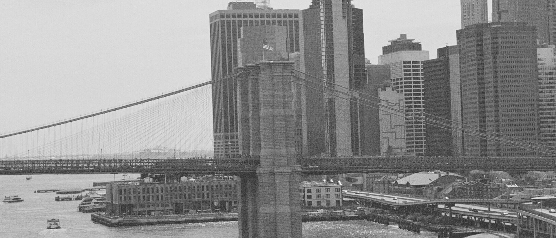 Schwarzweiß-Foto von einer Brücke und den Skylines in New York