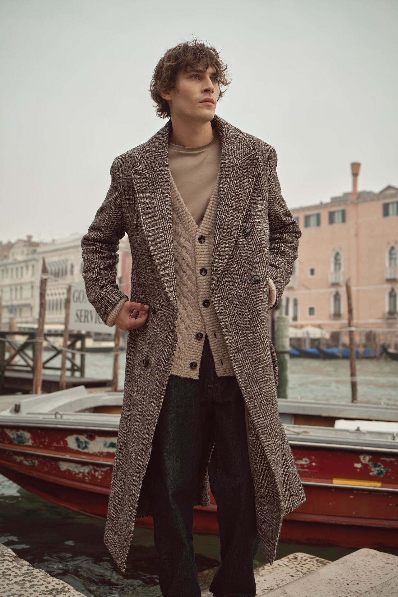 Männliches Modell in langen grauen Wollmantel von Bugatti posiert an einem Hafen