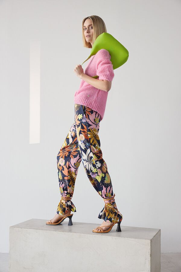Model in Blumenprint-Hose und pinkem Strickpullover von Joop