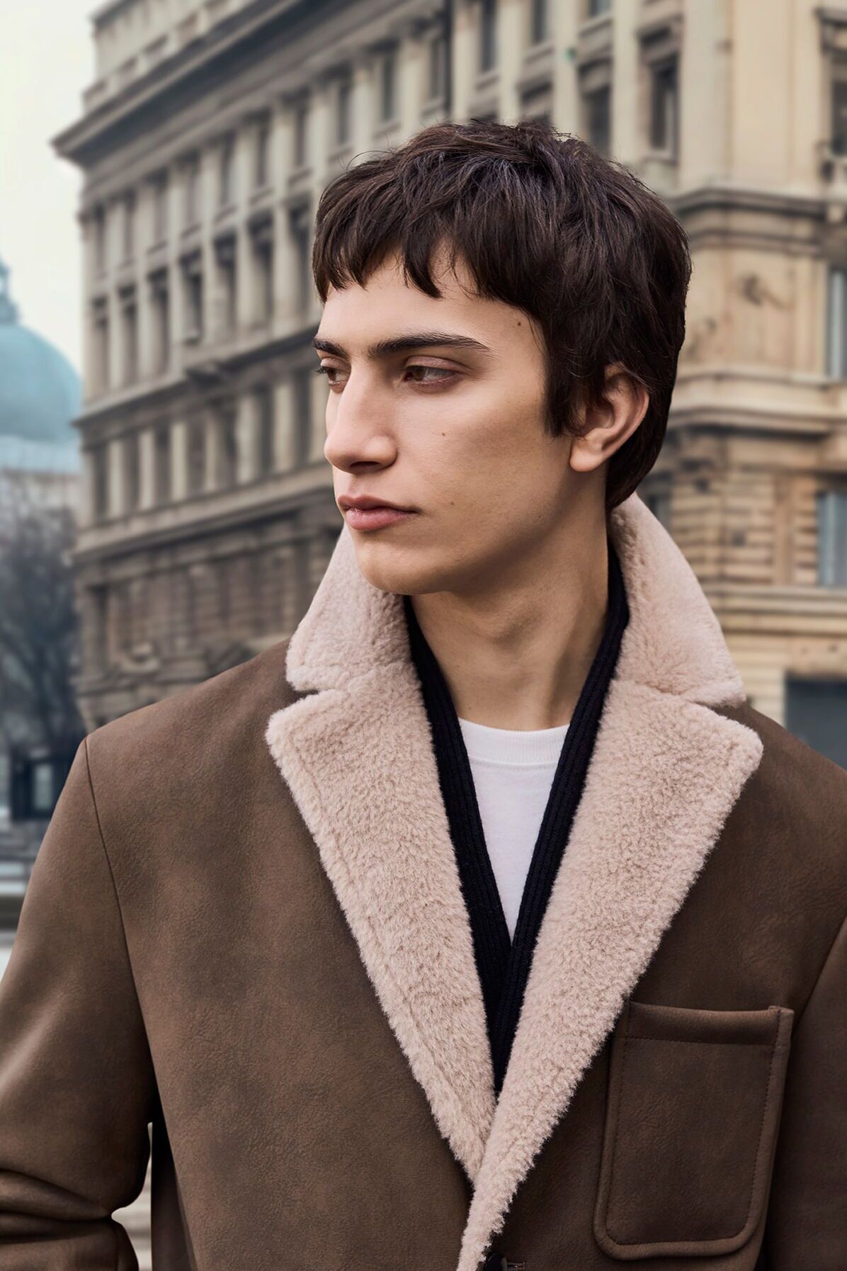 Männliches Modell in dunkelbrauner Jacke von CINQUE blickt zur Seite