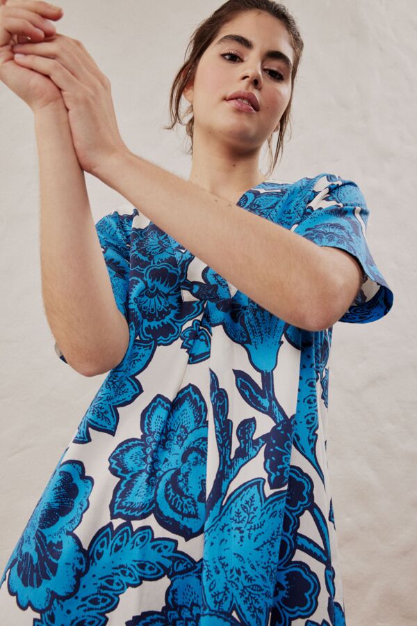 Weibliches Modell in weissem Kleid mit blauem Floralprint von Smith&Soul