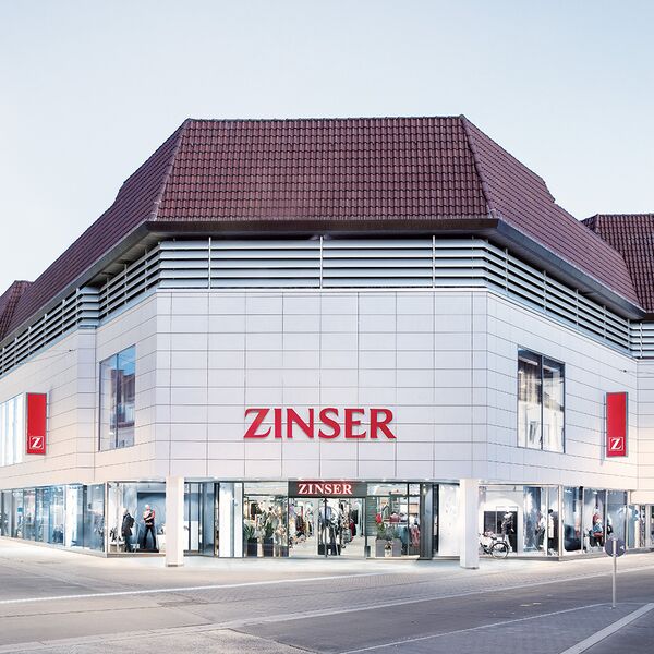 Außenansicht des Zinser-Kaufhauses mit großem Logo und Eingangsbereich.