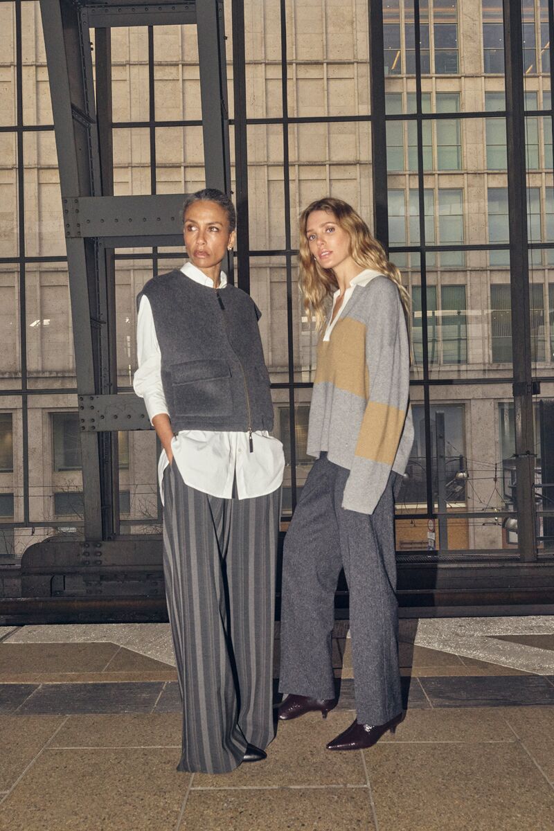 Zwei Weibliche Modells in moderner Businesmode für Damen posieren gemeinsam vor einer Fensterfassade