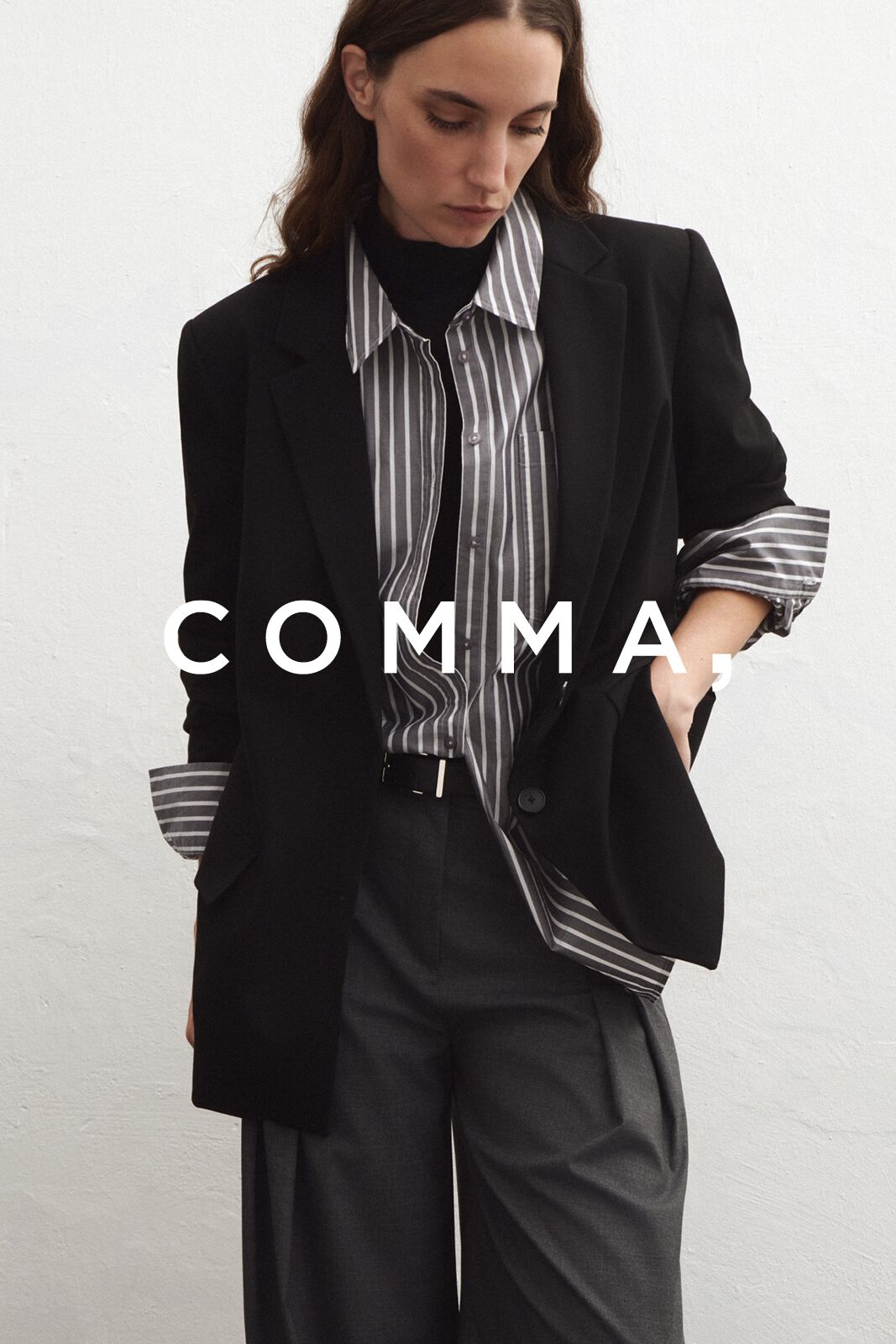 Weibliches Modell in stylischen Outfit von Comma posiert mit Blick auf den Boden