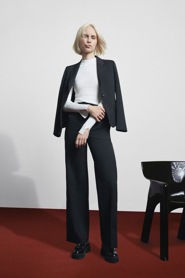 Weibliches Model in schwarzem Blazer und Hose von BOSS