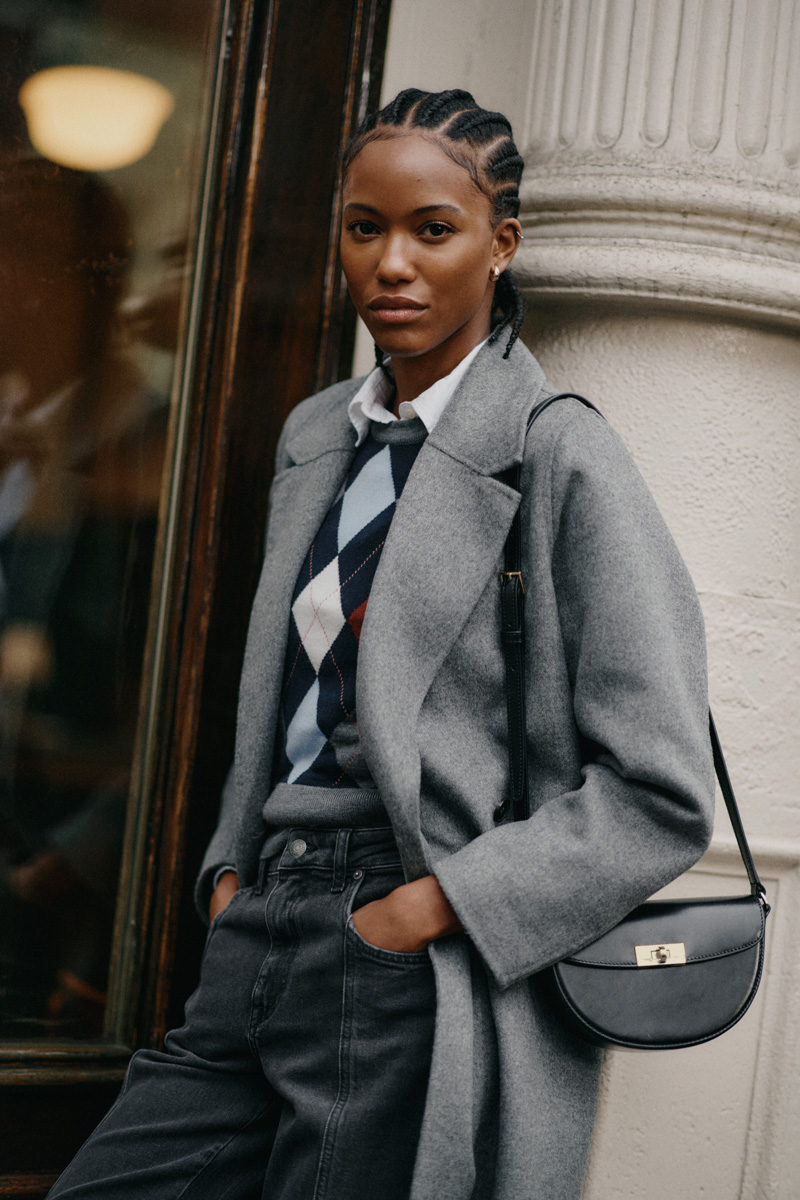 Weibliches Modell in grauen Mantel von Gant posiert mit den Händen in der Hosentasche